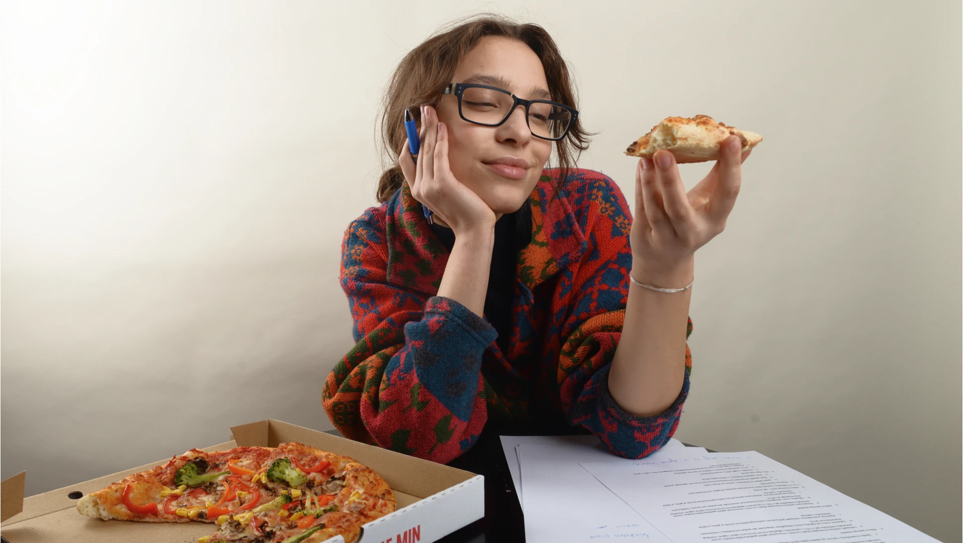 kobieta wpatrująca się z uczuciem w kawalek pizzy trzymany w ręce