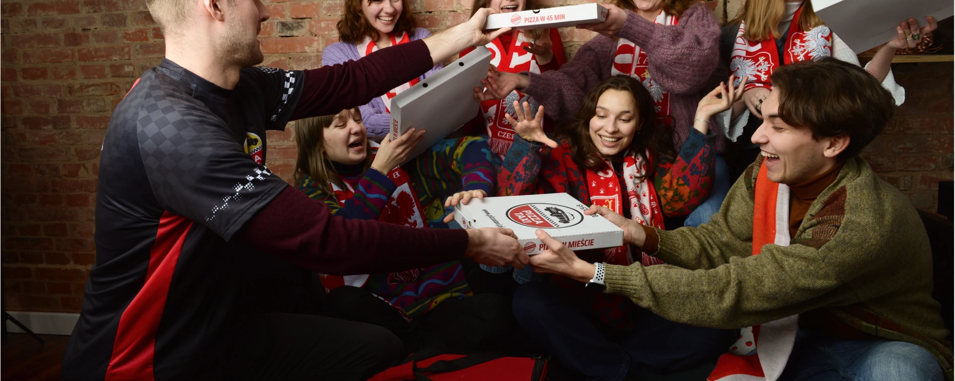 Grupa ludzi częstujących się pizzą